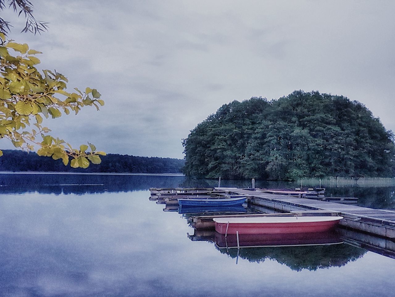 Boat moored in lake against sky