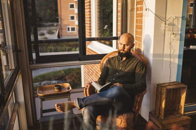 Man reading book on balcony