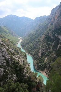 High angle view of river amidst mountains against sky