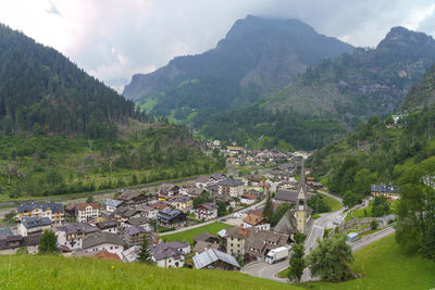 Aerial view of townscape and mountains against sky