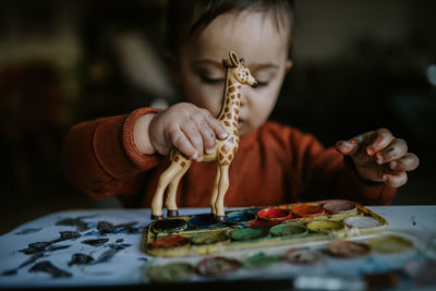 Close-up of baby boy playing with toy animal on table