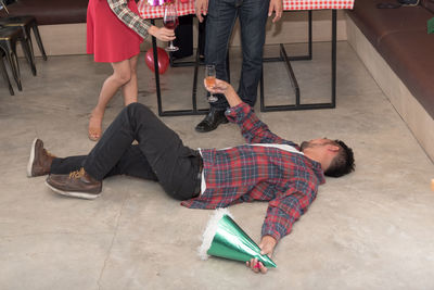 Drunk man lying on floor during party