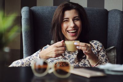 Portrait of a young woman drinking coffee