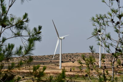 Low angle view of windmill on landscape against clear sky