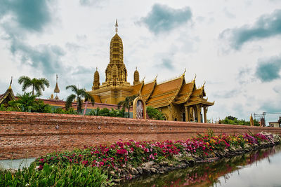 View of temple on building against cloudy sky