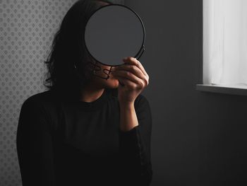 Close-up of woman holding eyeglasses at home