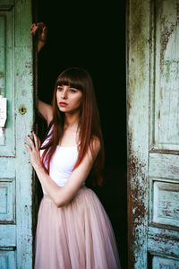 Young woman standing at doorway