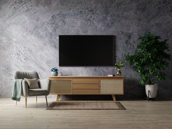 Smart tv in living room the concrete wall with armchair,minimal design.3d rendering