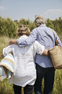 Couple with picnic basket and blanket going for picnic