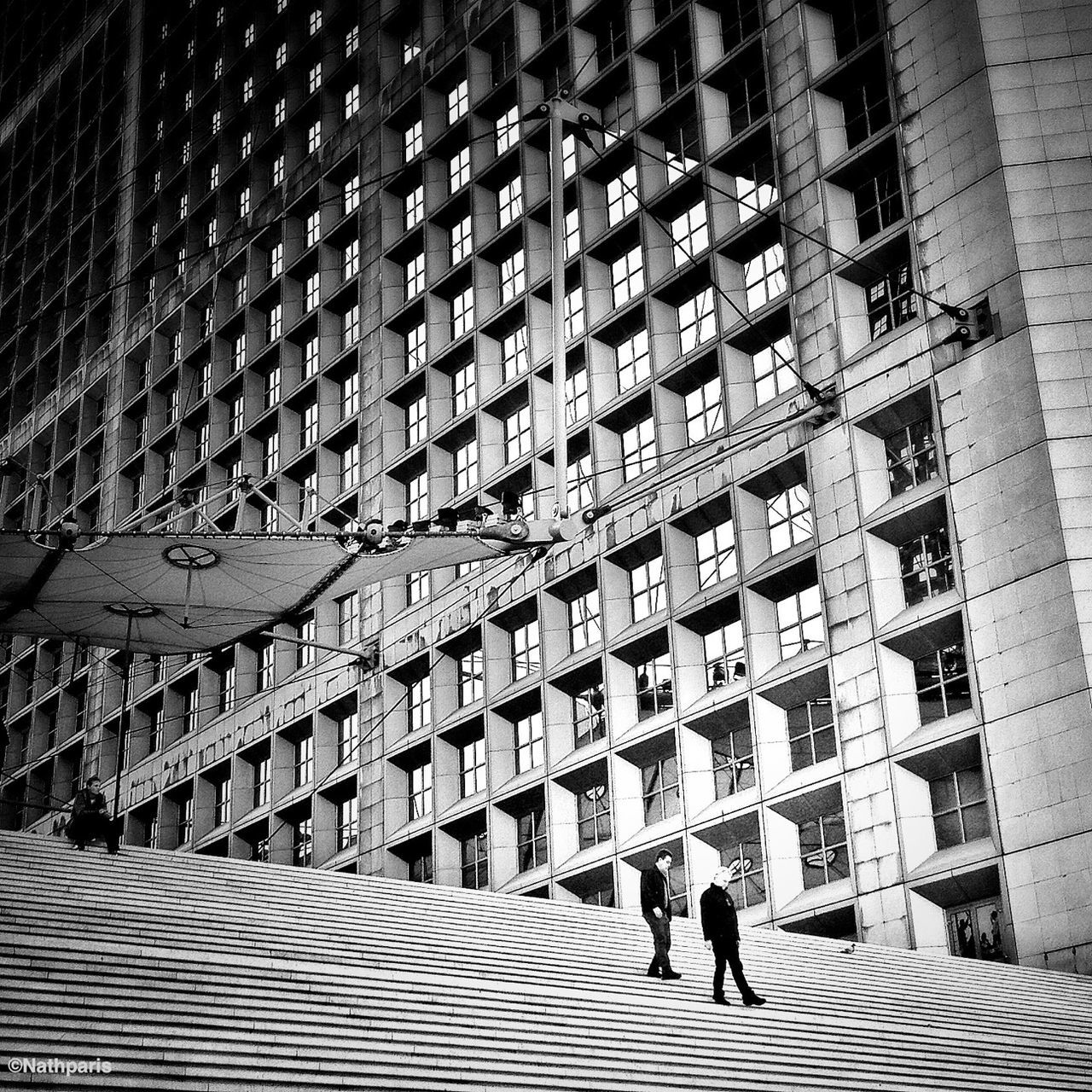 building exterior, architecture, built structure, city, pattern, building, city life, repetition, modern, office building, low angle view, men, outdoors, in a row, walking, day, shadow, street, high angle view