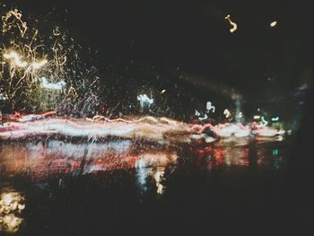 Close-up of illuminated water against sky at night