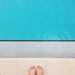 Low section of person against swimming pool