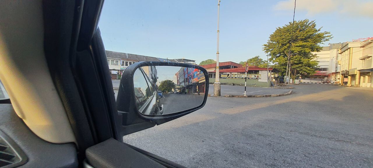 REFLECTION OF ROAD IN SIDE-VIEW MIRROR OF CAR