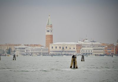 View of buildings and sea in city against clear sky