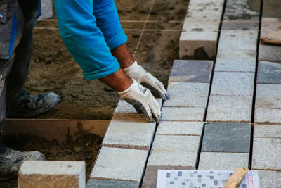 Low section of man working on footpath