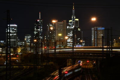 Illuminated buildings against sky at night