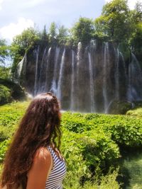 Rear view of woman looking at waterfall