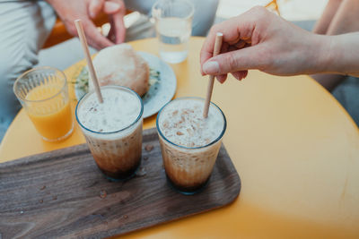 Cropped image of hand holding coffee cup on table
