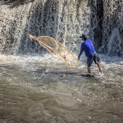 Full length of man splashing water