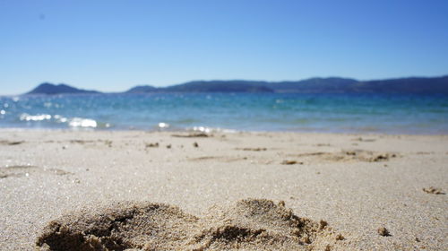 Scenic view of beach against blue sky