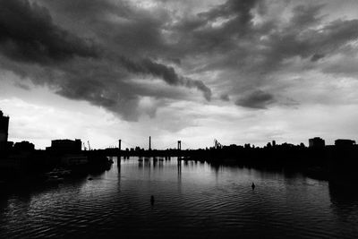 River in city against cloudy sky