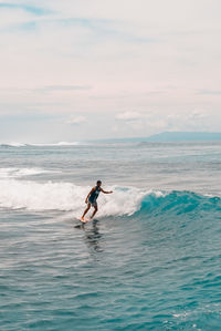 Man surfing in sea against sky