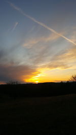 Scenic view of silhouette field against sky at sunset