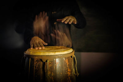 Blurred motion of man playing conga in darkroom