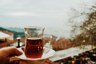 Close-up of hand holding drink on table