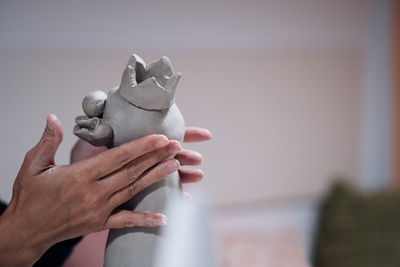 Cropped image of hand working on ceramic sculpture at workshop