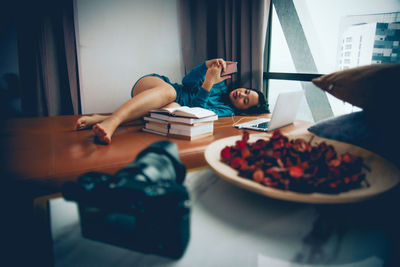 Midsection of woman reading book at home