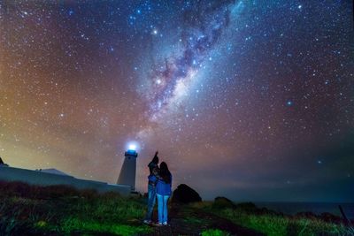 Low angle view of couple standing against star field