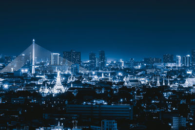 Illuminated cityscape against clear sky at night