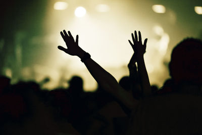 Silhouette of man with arms raised in background