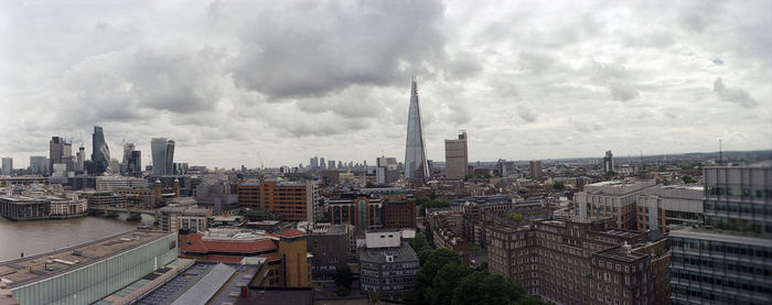 View of cityscape against cloudy sky