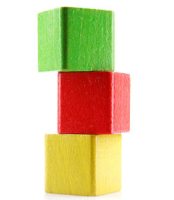Close-up of multi colored wooden blocks stacked against white background