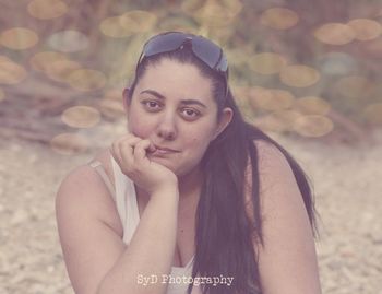 Portrait of beautiful young woman lying on land