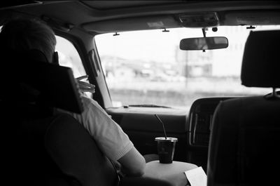 Rear view of woman sitting in car