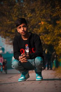 Boy crouching on street