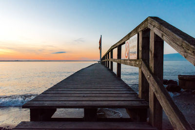 Pier over sea against sky during sunset