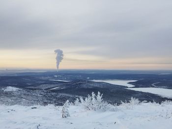 Scenic view of snow covered land against sky