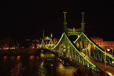 Illuminated liberty bridge over danube river at night