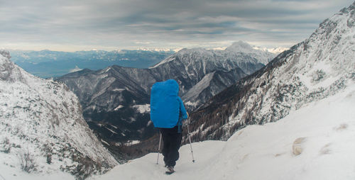 Rear view of person on snowcapped mountains against sky