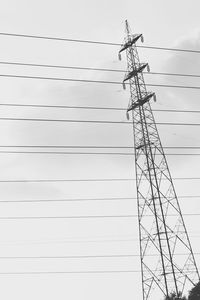 Low angle view of electricity pylon against clear sky