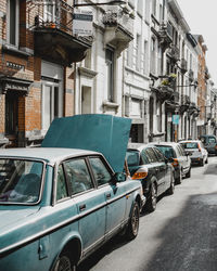 Cars on road by buildings in city