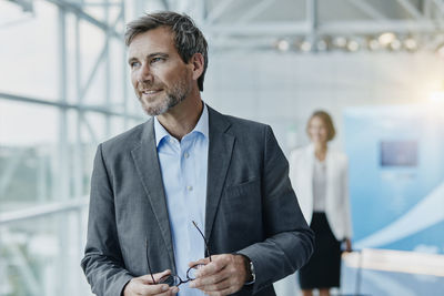 Smiling businessman and businesswoman at the airport