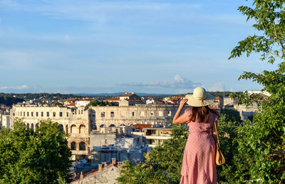 Rear view of woman standing on viewpoint overlooking city of pula, croatia