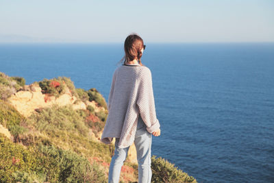 Rear view of man looking at sea against sky