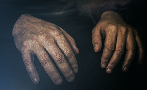 Midsection of man sitting in darkroom