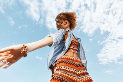 Side view of woman using mobile phone against sky